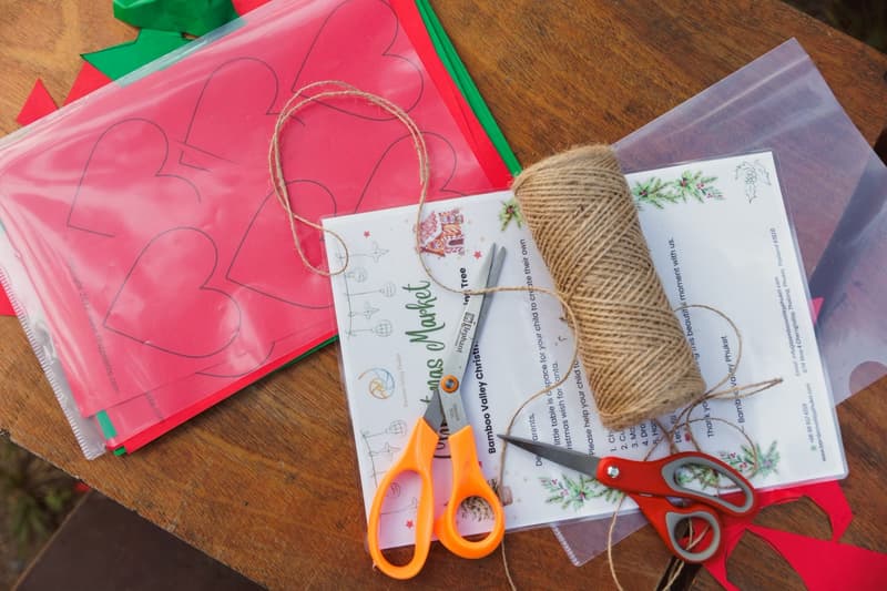Paper hearts, twine and scissors ready for a Christmas craft