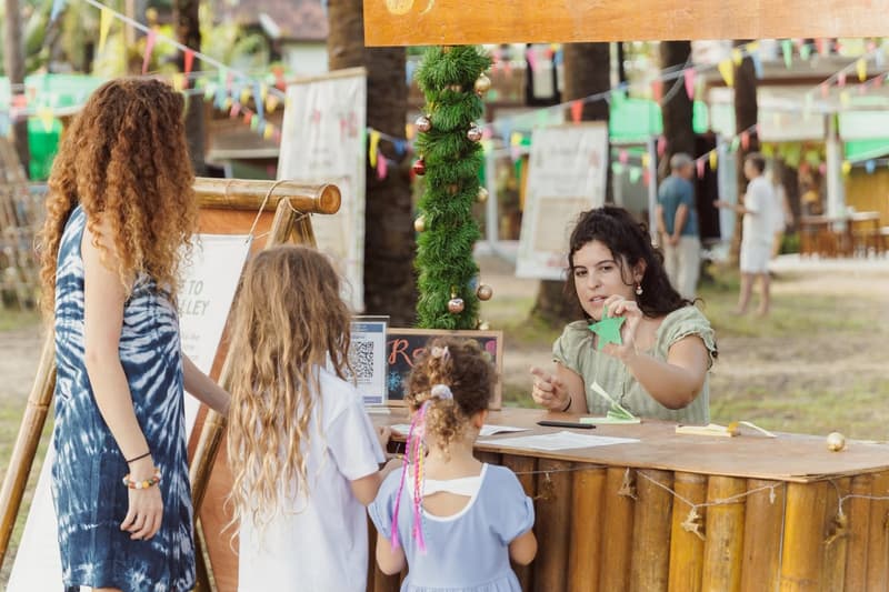 A girl makes a paper star at a craft stall