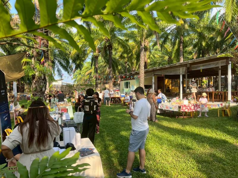 ร้านค้าและครอบครัวบนสนามหญ้า มองผ่านใบไม้สีเขียว