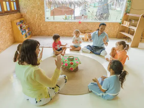 A teacher leading a circle of children on a round carpet