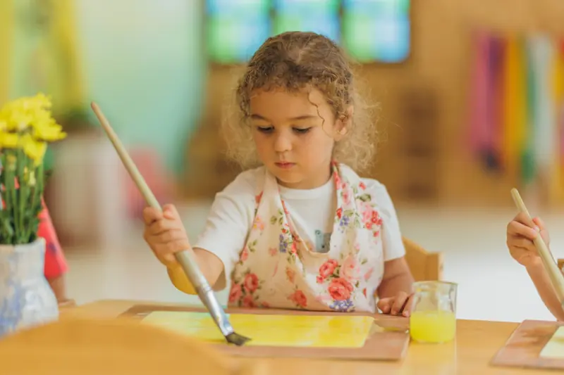 A girl absorbed in a yellow watercolour painting
