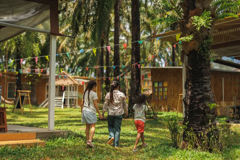A teacher walking hand in hand with three girls under the bunting